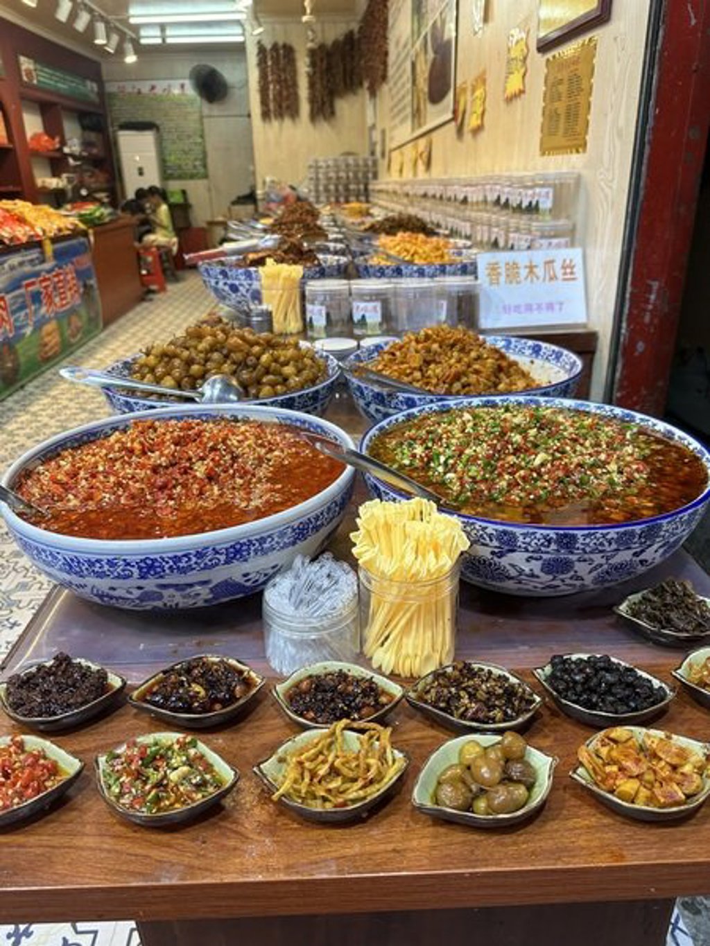Chinese markt met grote schalen pittige gerechten en kruiden, onderdeel van de groepsrondreis China Hoogtepunten.