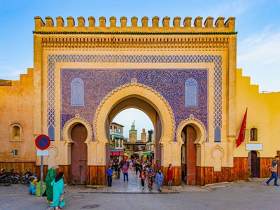 Blauwe Bab Bou Jeloud-poort in Fès met mozaïeken en drukke medina-ingang, Marokko.