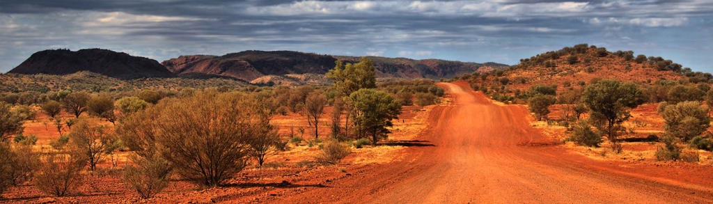 Rode zandweg door de outback in Australië, tijdens een groepsrondreis van Sydney naar Darwin.