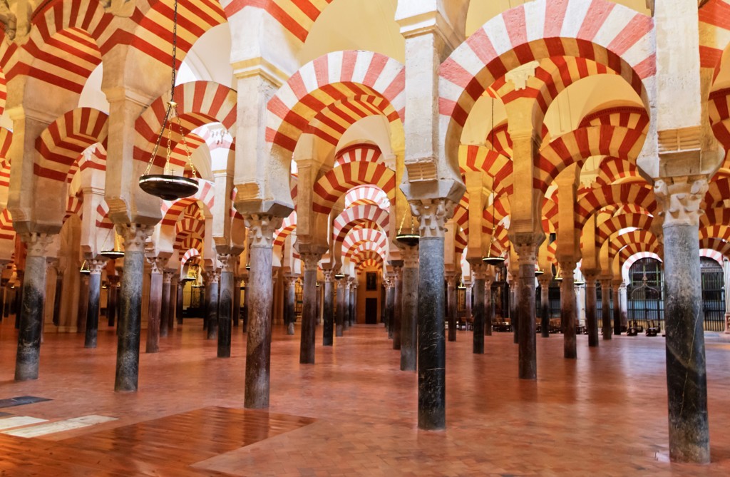 Interieur van de Mezquita in Córdoba met rood-wit gestreepte bogen en zuilen tijdens een 22-35ers reis door Andalusië.