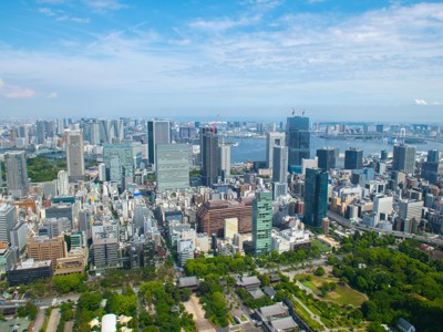 Uitzicht over de skyline van Tokio met wolkenkrabbers, groene parken en de baai op de achtergrond.
