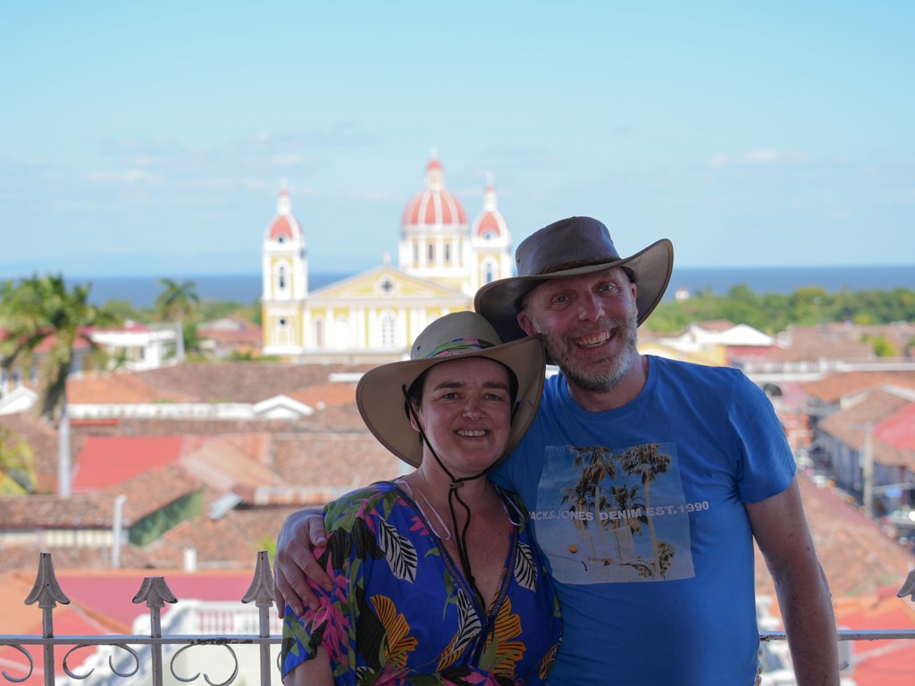 Reizigers met hoeden poseren met uitzicht op de kathedraal van Granada tijdens groepsrondreis Nicaragua en Costa Rica.