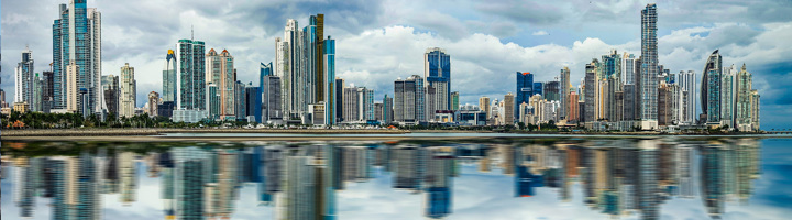 Skyline van Panama-Stad met wolkenkrabbers langs de kust en weerspiegeling in het water.