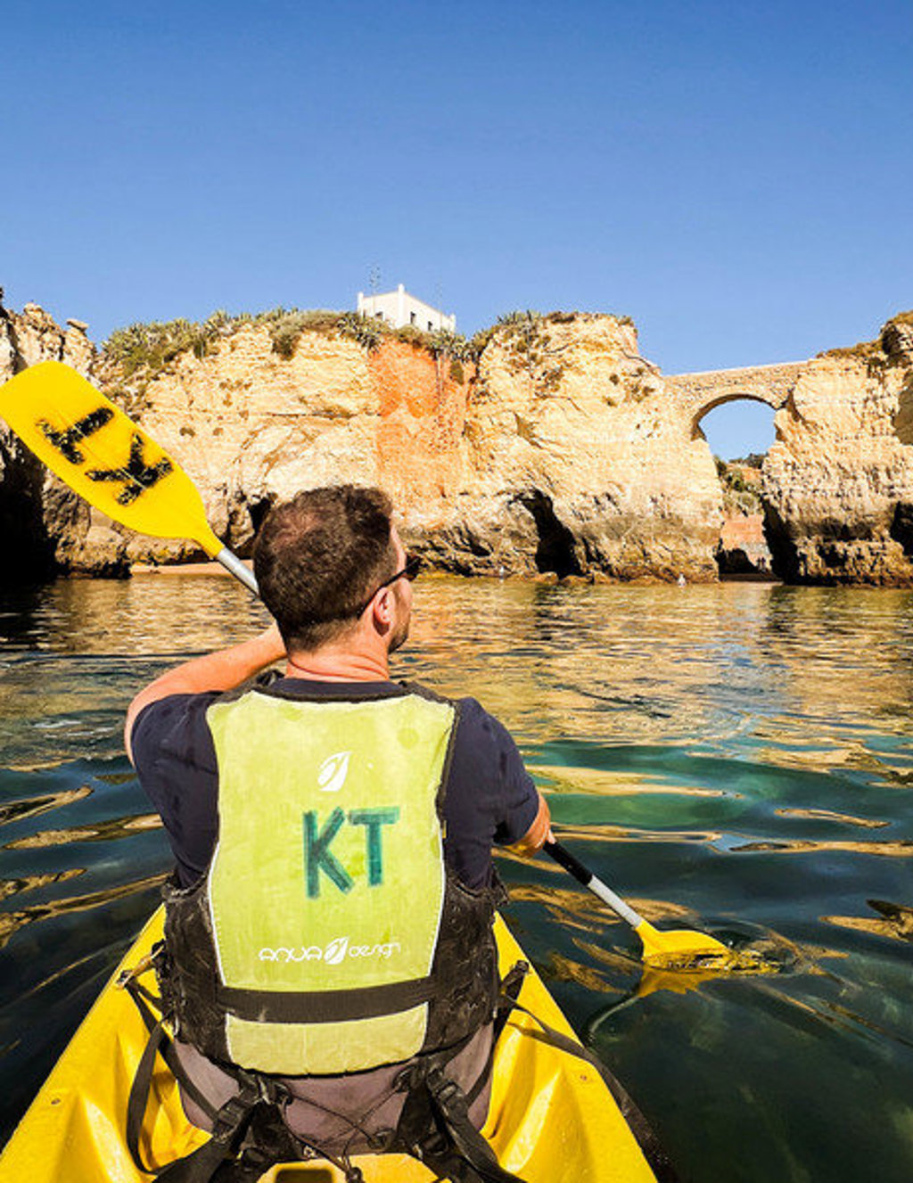 Kajakker bij rotskliffen en natuurlijke boog aan de kust van Portugal tijdens 22-35ers reis Madeira & Portugal.