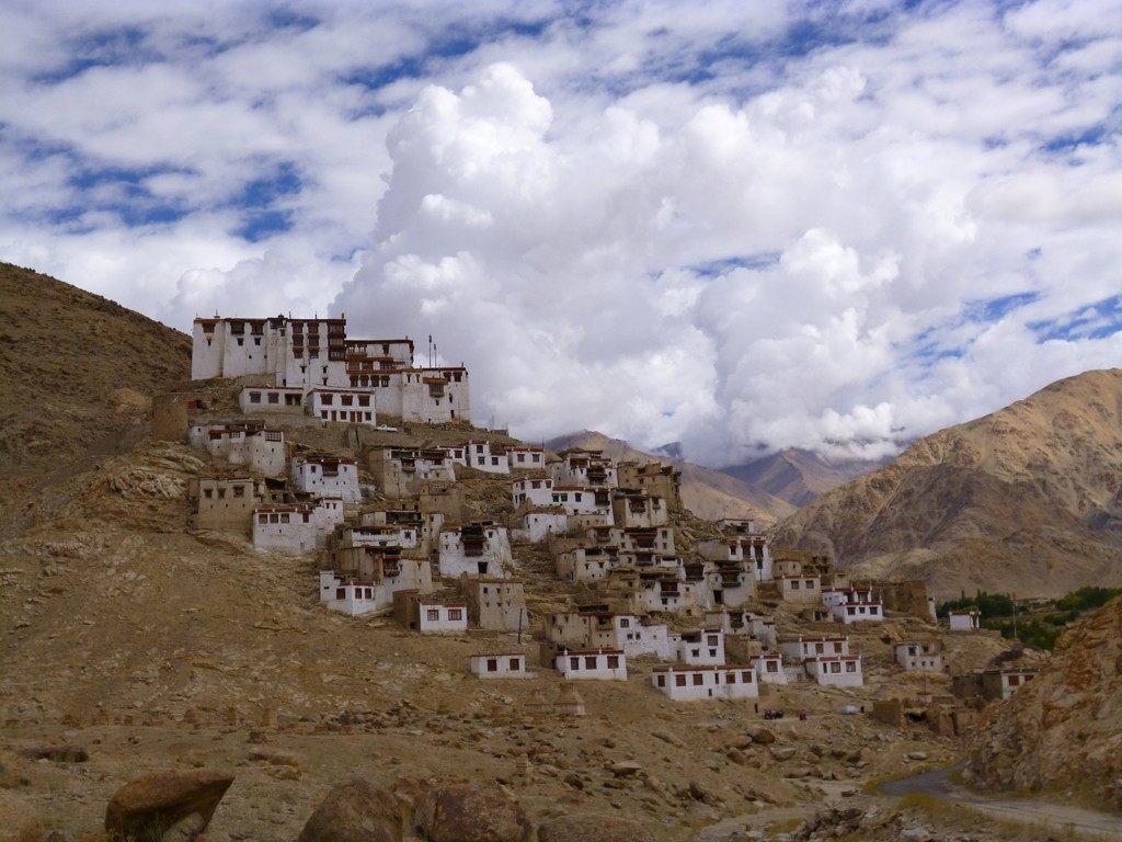 Kloostercomplex op een heuvel in Ladakh, India, met berglandschap en wolkenlucht.