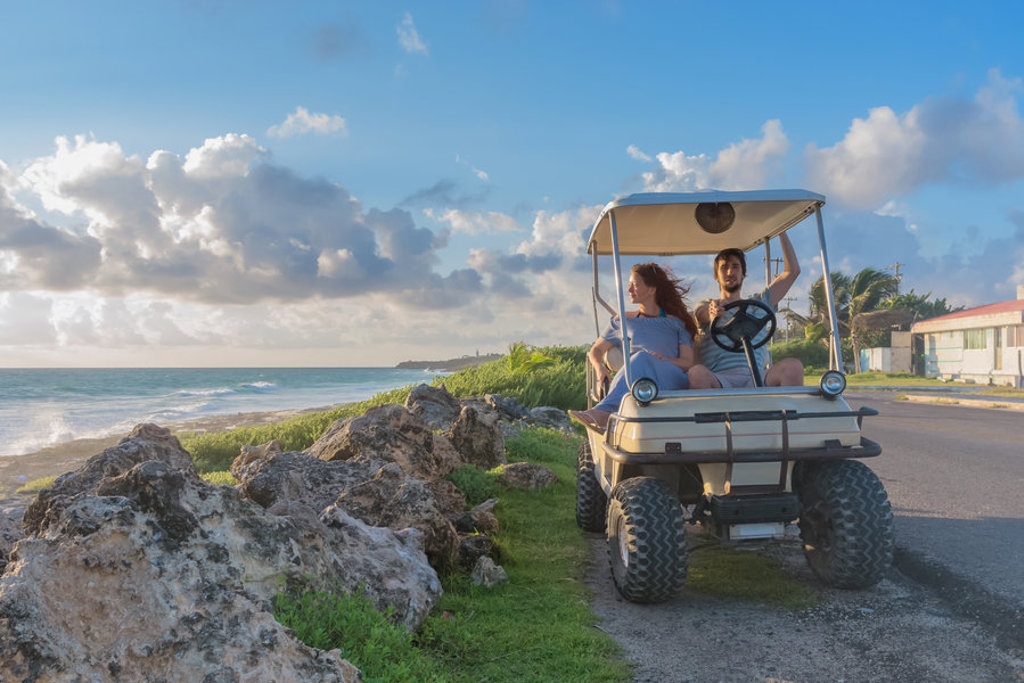 22-35ers reis Mexico: reizen langs de kust in een golfkar met uitzicht op zee en wolkenlucht.