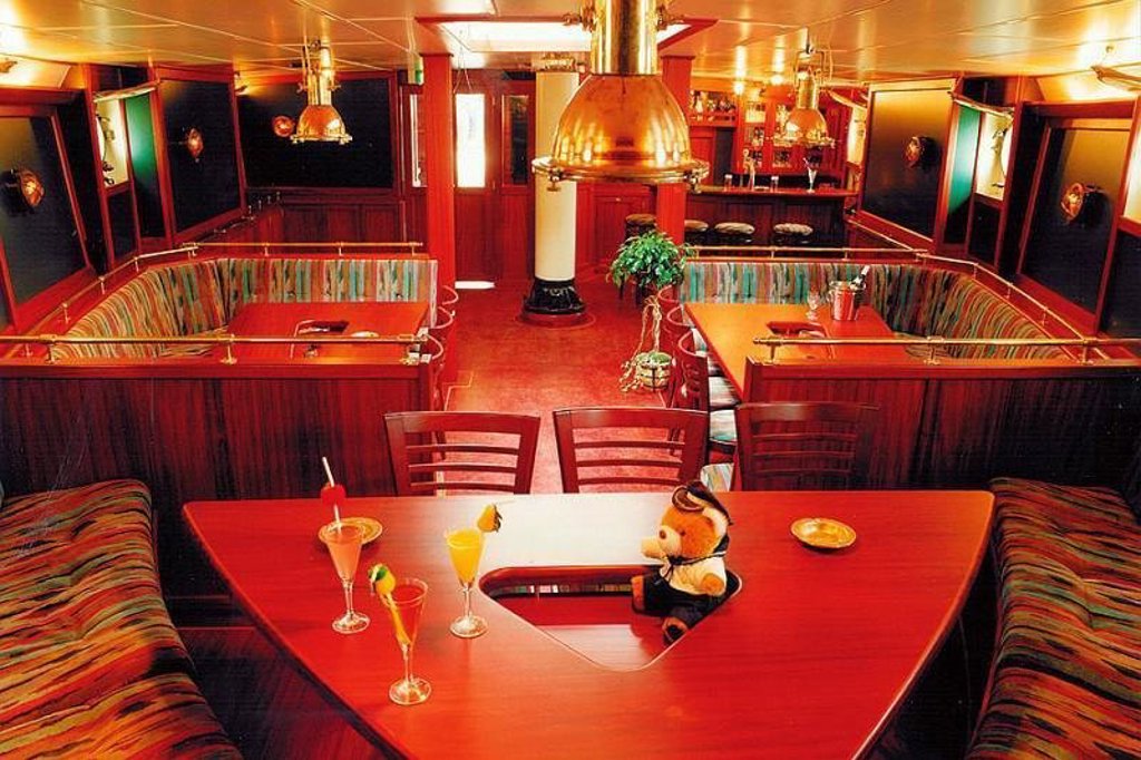 Interieur van zeilschip Antigua tijdens groepsrondreis Noorwegen, met zitruimte en uitzicht op zee.