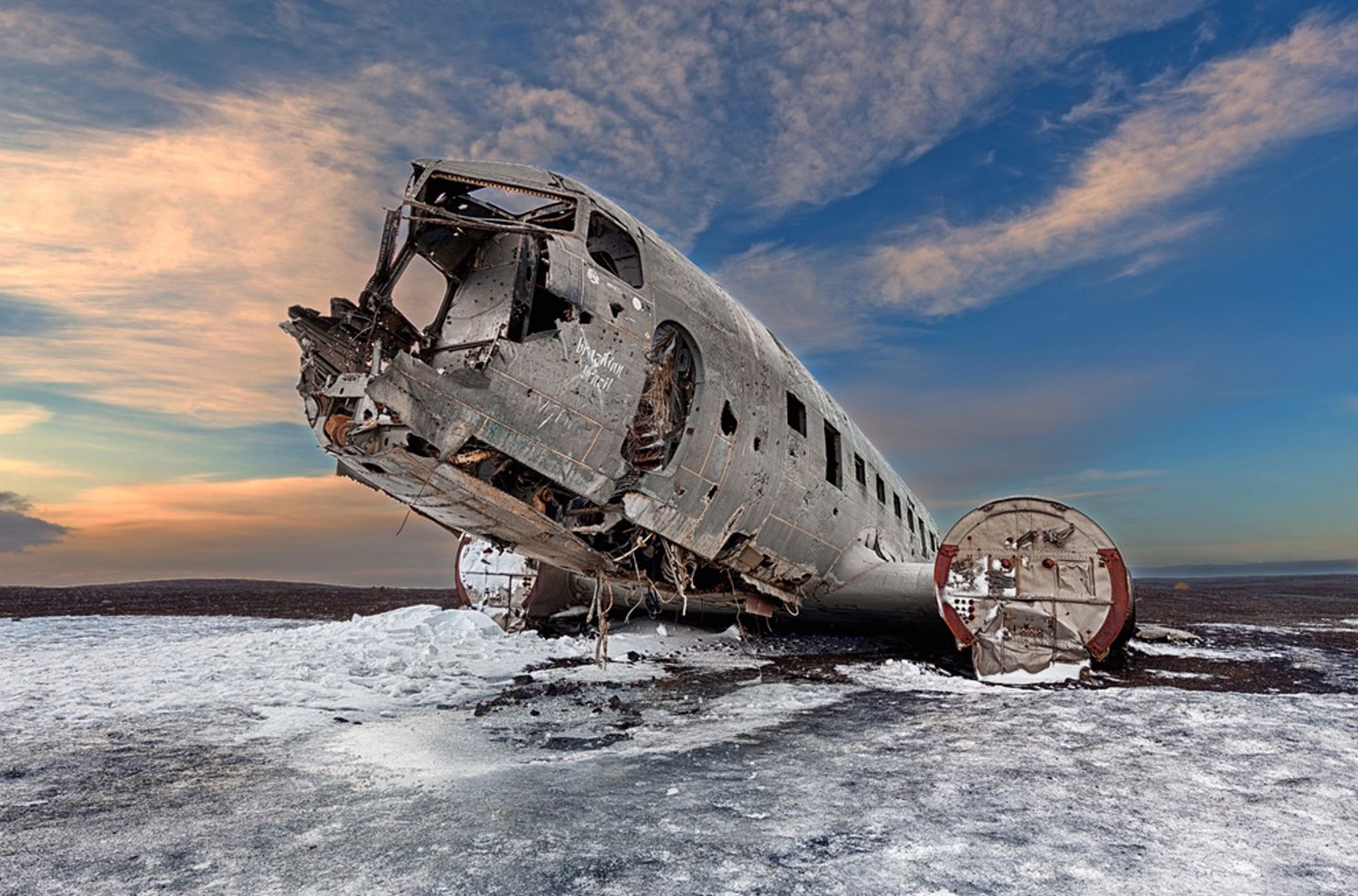 Vliegtuigwrak DC-3 op het zwarte zand van Sólheimasandur, IJsland, bij zonsondergang.