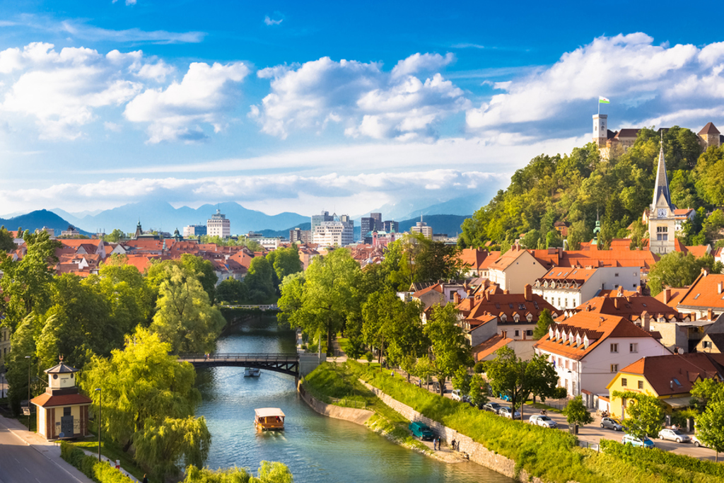 Uitzicht over Ljubljana met de rivier de Ljubljanica, rode daken en Ljubljana Castle op de heuvel.