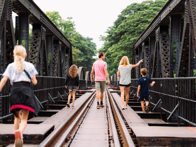 Gezin wandelt over de spoorbrug van de River Kwai bij Kanchanaburi tijdens de Route Thailand Noord en Zuid.