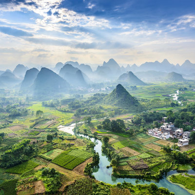 Karstbergen en rijstvelden langs een kronkelende rivier in China tijdens een groepsrondreis.
