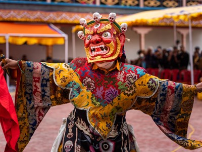 Gemaskerde danser in kleurrijk kostuum tijdens kloosterfestival op de route Spiti & Ladakh.