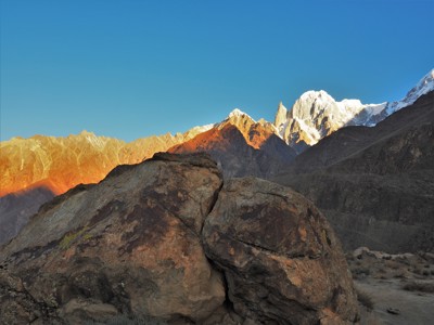 Rotsblok met uitzicht op besneeuwde bergtoppen in Baltistan en Hunza, Pakistan.
