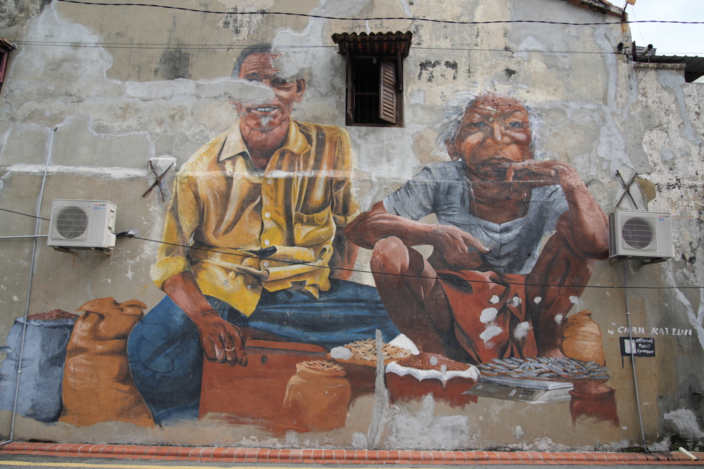Muurschildering van twee marktverkopers op een gevel in Georgetown, Penang, tijdens familiereis Maleisië.