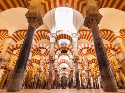 Interieur van de Mezquita in Córdoba met rood-wit gestreepte bogen en zuilen, Andalusië-route.