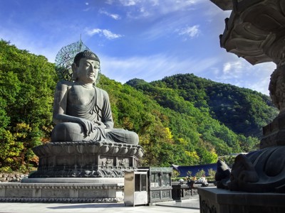 Groot Boeddhabeeld bij een tempel in de bergen van Zuid-Korea onder een heldere blauwe lucht.