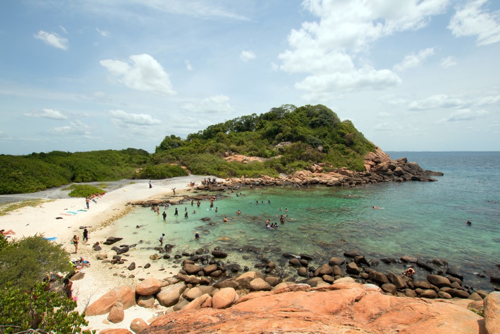 Uitzicht op een baai met strand en helder water tijdens een 22-35ers reis in Sri Lanka.