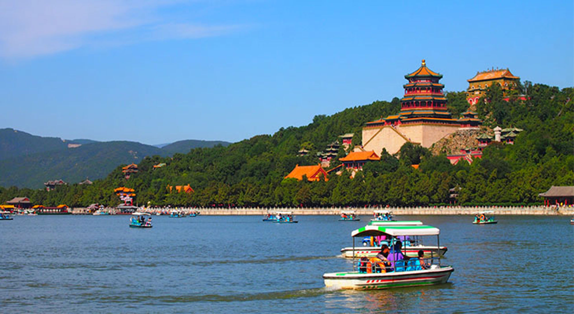 Zomerpaleis in Beijing met tempels op de heuvel en bootjes op het Kunmingmeer.