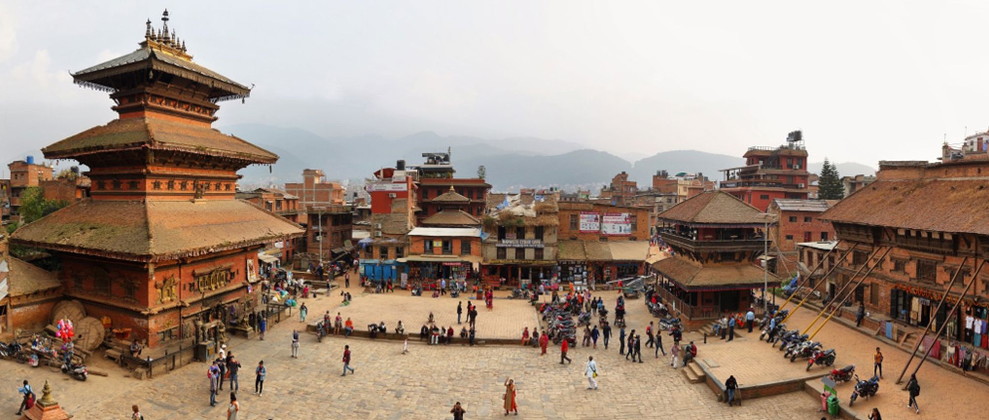 Durbar Square in Bhaktapur, Nepal, met pagodetempel en levendig plein met historische gebouwen en bezoekers.