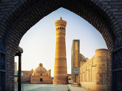 Minaret en moskeecomplex in Buchara, Oezbekistan, gezien door een bakstenen poort.