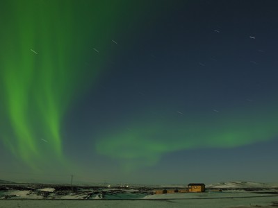 Noorderlicht boven een besneeuwd landschap in IJsland tijdens de winterroute.