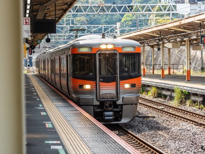 Oranje-grijze trein in Japan die het station binnenrijdt, onderdeel van Route Japan 16 dagen .