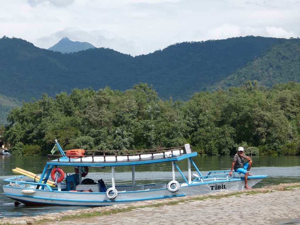 Boot op een rivier met groene bergen op de achtergrond tijdens de groepsrondreis Brazilië en Buenos Aires.