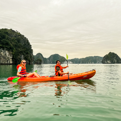 Kajakken tussen kalkstenen rotsen in Ha Long Bay tijdens een 22-35ers reis Vietnam.
