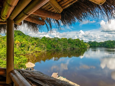 Uitzicht vanaf een lodge op een rustige rivier omringd door regenwoud in Ecuador.