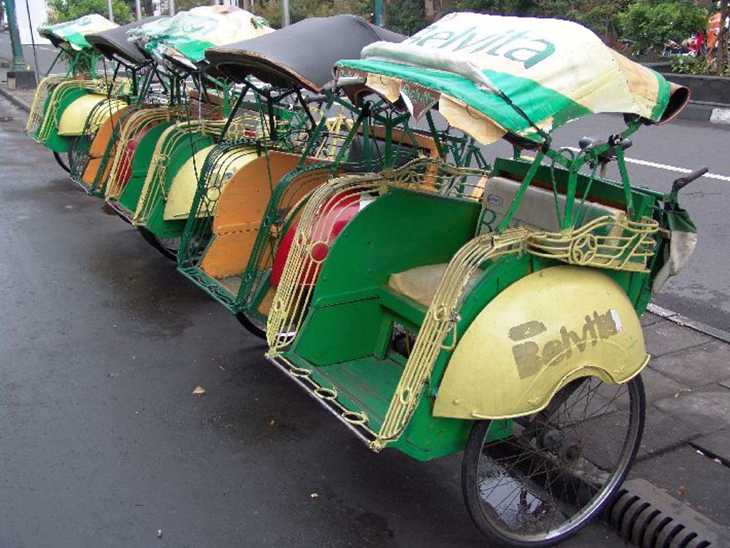 Rij riksja’s langs de straat op Java, Indonesië, tijdens een groepsrondreis Java, Bali en Lombok.