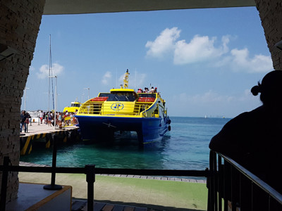Gele veerboot bij de pier op Cozumel, Mexico, klaar voor overtocht naar Playa del Carmen.