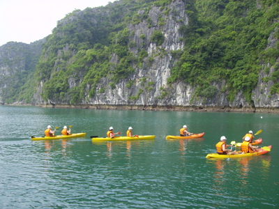 Kajakken in Halong Bay langs groene kalksteenrotsen tijdens Route Vietnam.