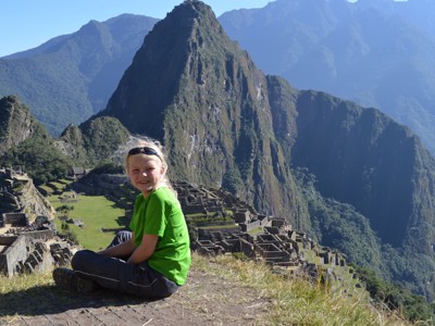 Kind met uitzicht op Machu Picchu en de omliggende Andesbergen in Peru.