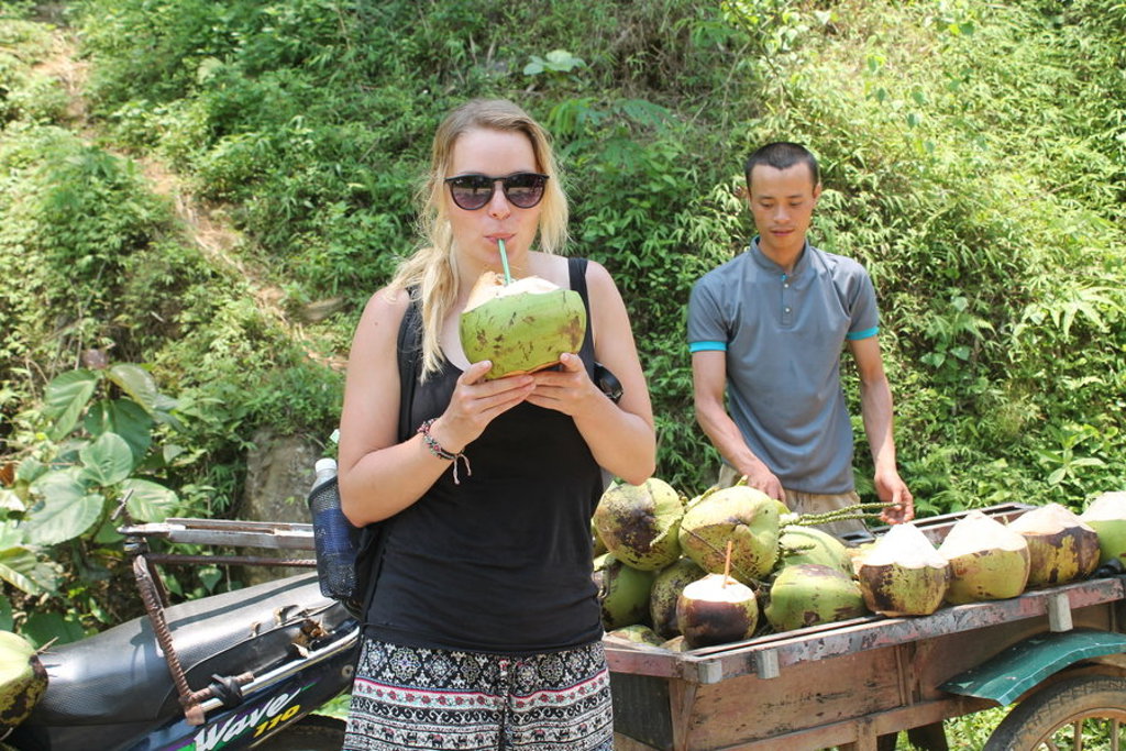 Reiziger drinkt kokoswater bij een kraam tijdens 22-35ers reis Vietnam.