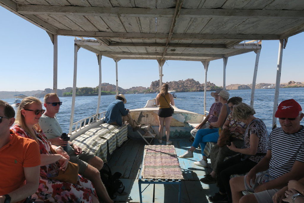 Reizigers op een boot op de Nijl tijdens een groepsrondreis Egypte, met uitzicht op de rivier en oevers.