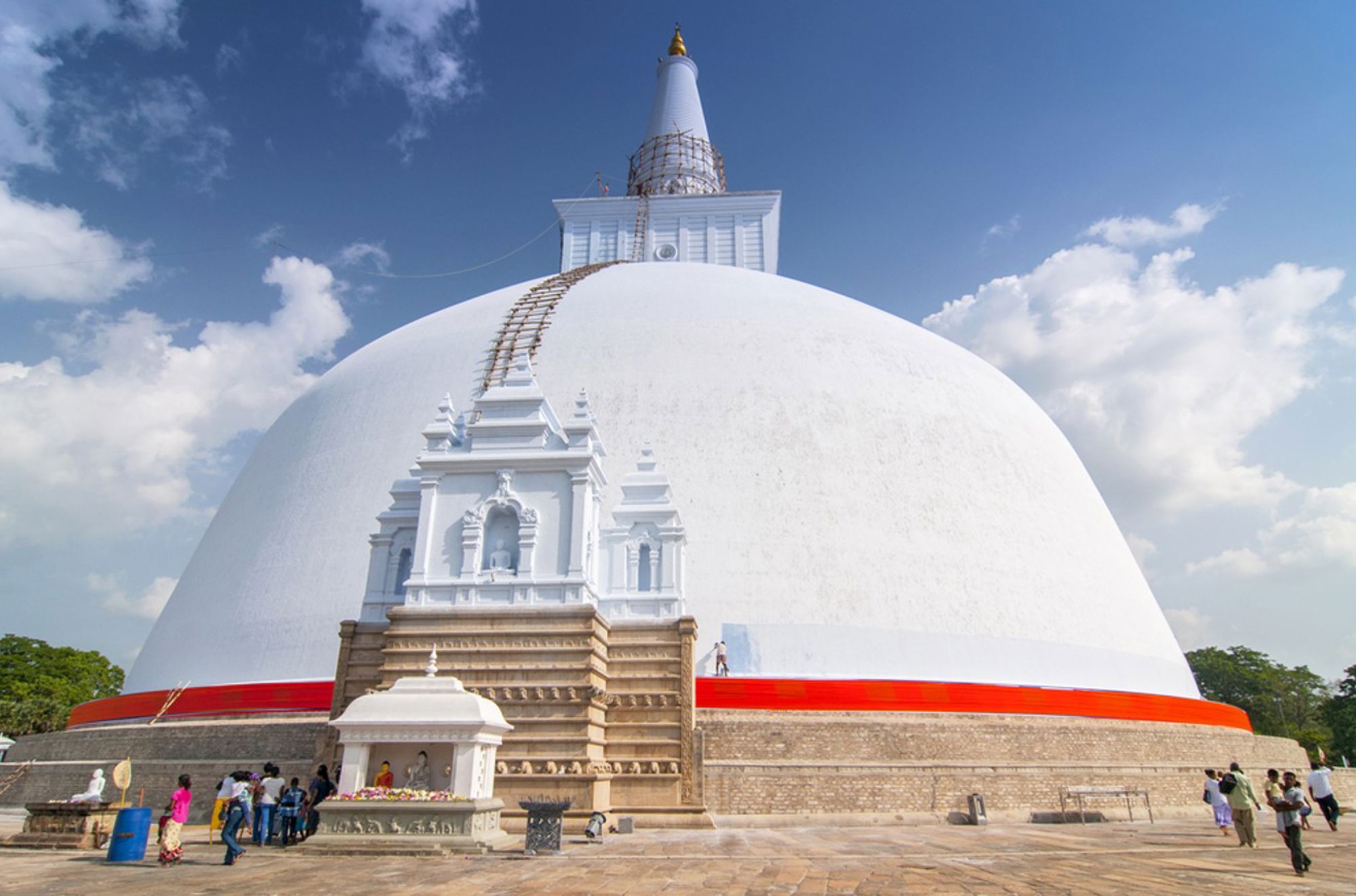 Ruwanwelisaya stoepa in Anuradhapura, Sri Lanka, met witte koepel en rode band onder een blauwe lucht.