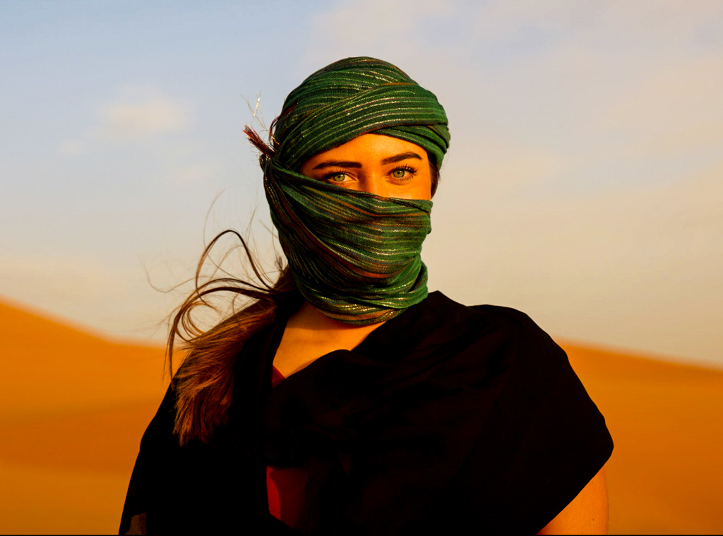 Vrouw met groene hoofddoek in de Marokkaanse woestijn tijdens een 22-35ers reis Marokko.
