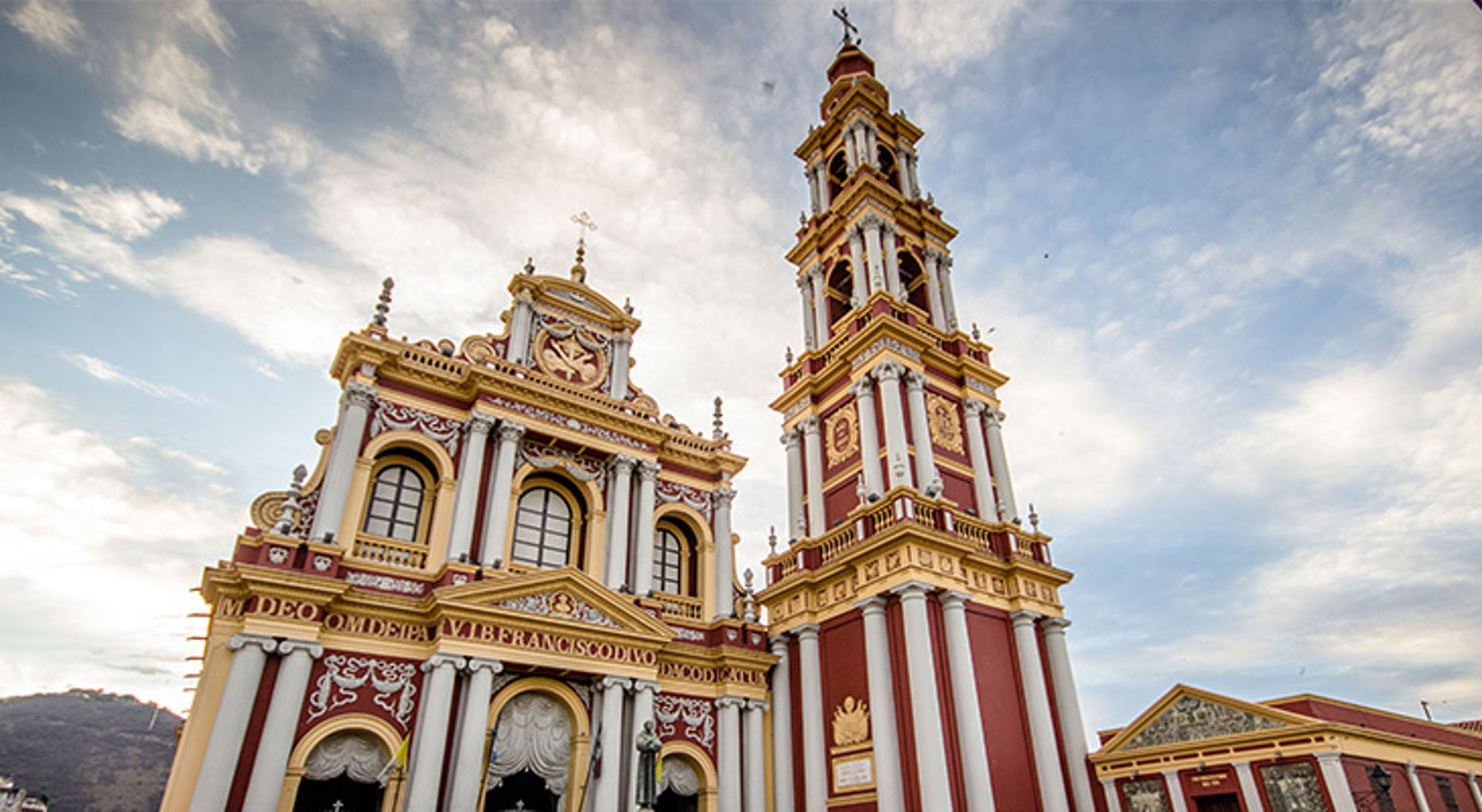 Francisco Cathedral Salta Kleurrijke kathedraal met hoge klokkentoren in Salta, Argentinië, tegen een blauwe lucht.