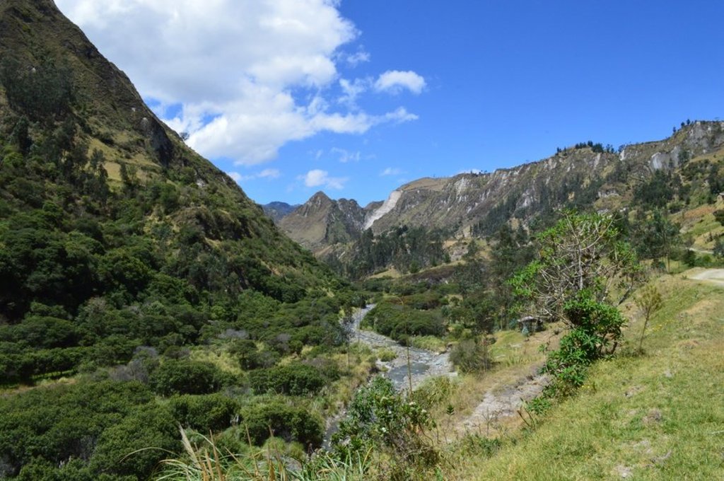 Uitzicht op groene Andesbergen in Ecuador tijdens een groepsrondreis, met wolken boven de bergkammen.