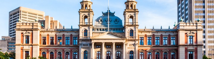 Zuid-Afrikaanse regeringsgebouw Union Buildings in Pretoria, met koepel en torens tegen een blauwe lucht.