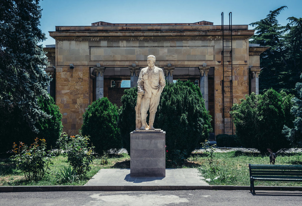 Standbeeld in een park bij een historisch gebouw in Georgië tijdens een familiereis.