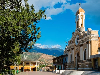 Kerk op het centrale plein van Alausí in Ecuador, met bergen op de achtergrond.