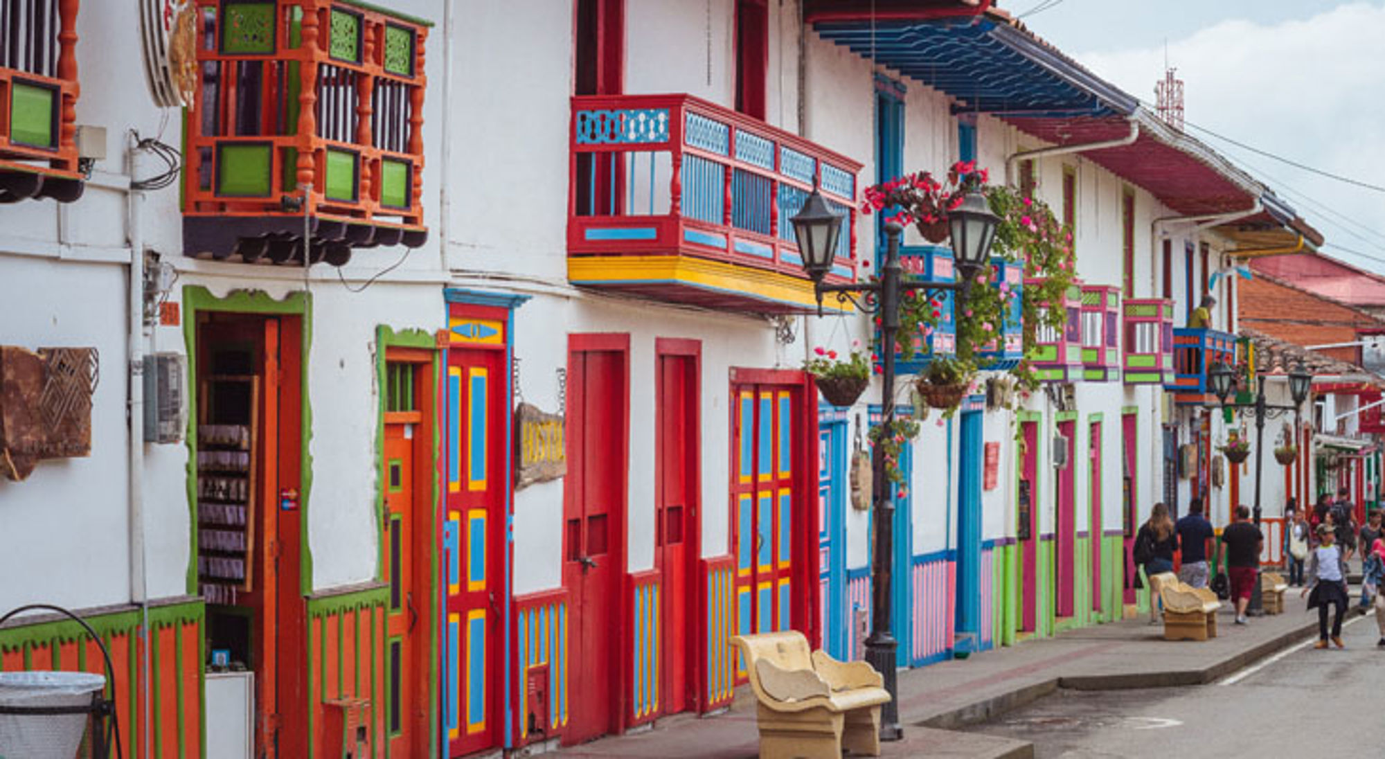 Kleurrijke straat Salento Kleurrijke straat met traditionele balkons en huizen in Colombia, met wandelaars langs de stoep.