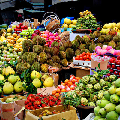Kleurrijke fruitkraam op een markt in Thailand, met durian, mango’s en bananen tijdens de Familiereis Thailand Comfort-Plus.