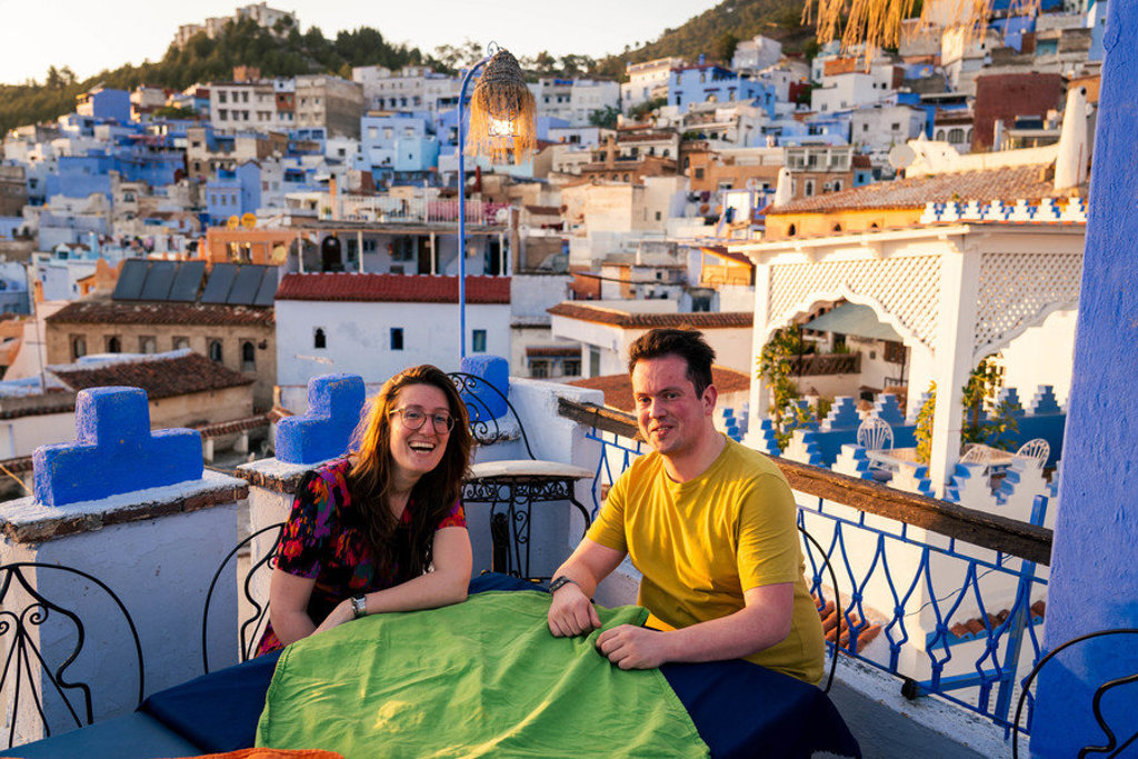 22-35ers genieten op een dakterras in Chefchaouen met uitzicht op de blauwe medina in Marokko.