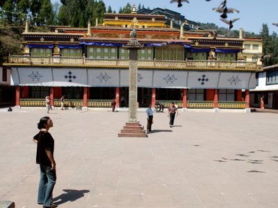 Binnenplaats van een boeddhistisch klooster in Sikkim met gebedszuil en bezoekers.