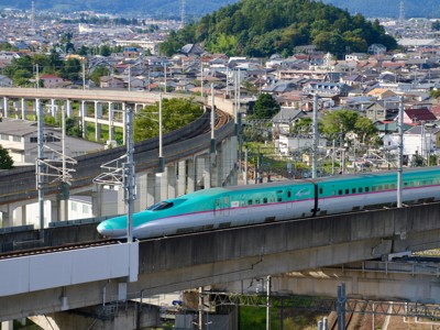 Shinkansen hogesnelheidstrein rijdt over viaduct langs Japanse stad, Route Japan.