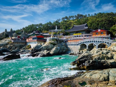 Haedong Yonggungsa-tempel aan de rotskust bij Busan, Zuid-Korea, met brug en turquoise zee.