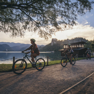 Fietsers langs het Meer van Bled in Slovenië tijdens zonsondergang.