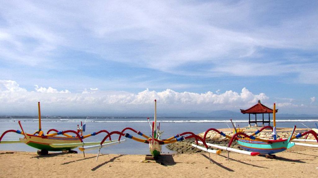 Traditionele vissersboten op het strand van Bali bij een klein paviljoen aan zee.